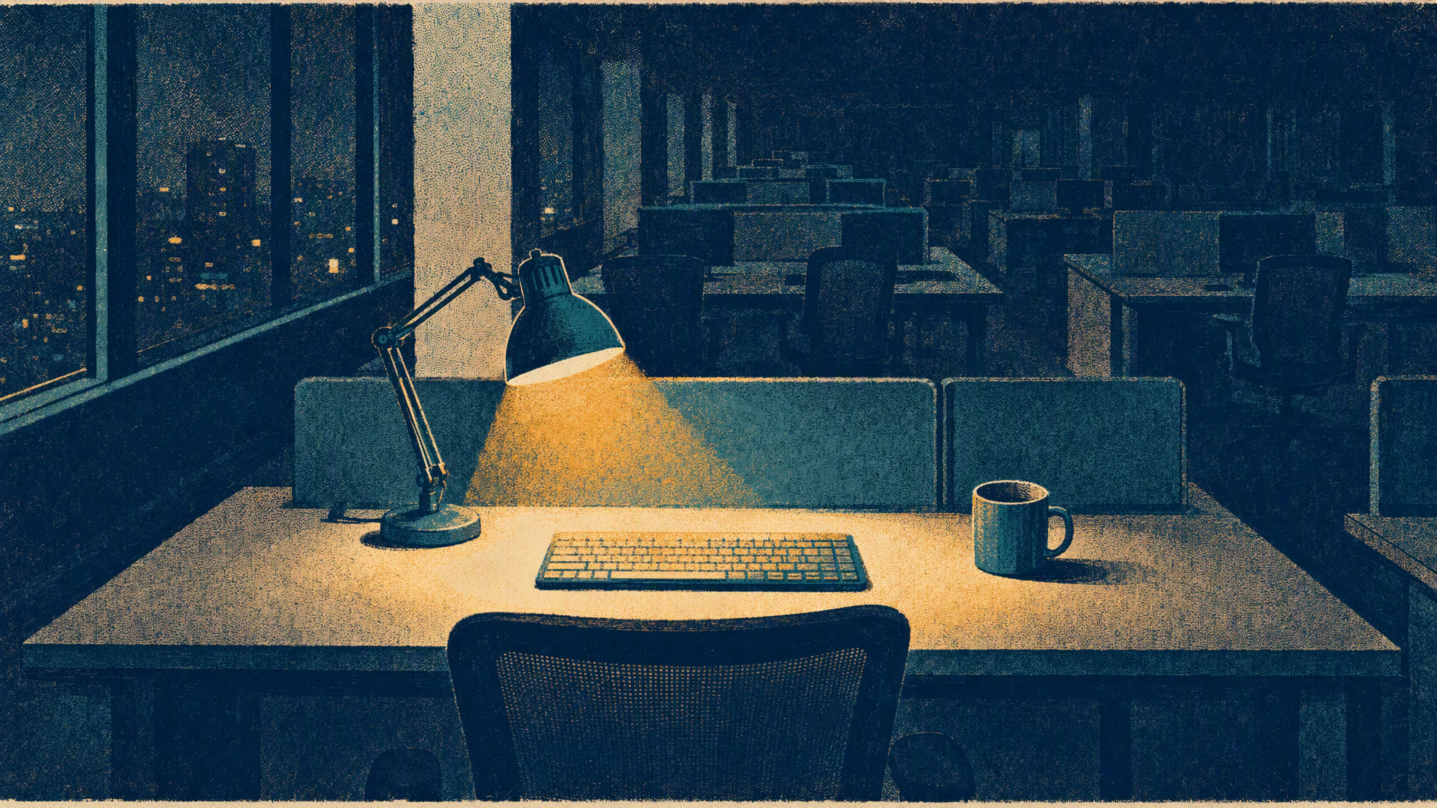 A single desk lamp lit at night over an empty office desk with a keyboard and a cold mug of coffee beside it.