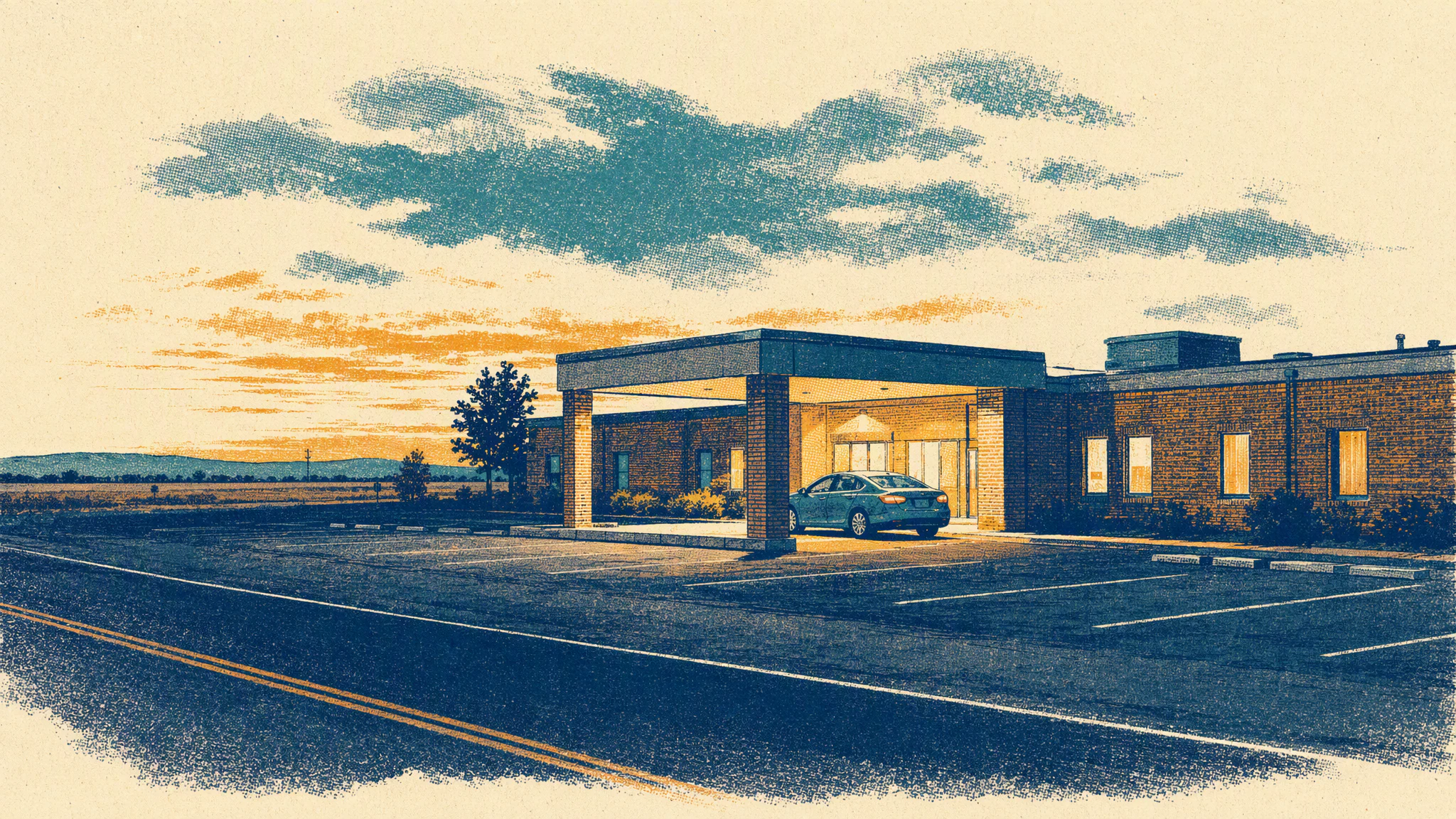 A low brick hospital building beside a two-lane road at dusk, with one car parked under the entrance canopy.