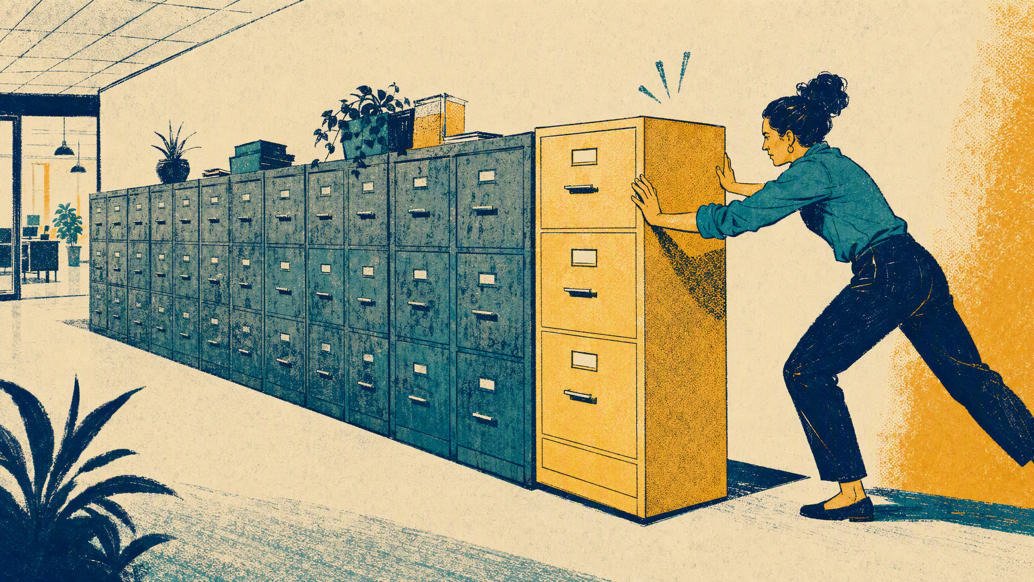 A worker pushes a new filing cabinet into place at the end of a row of identical cabinets in an office corridor.